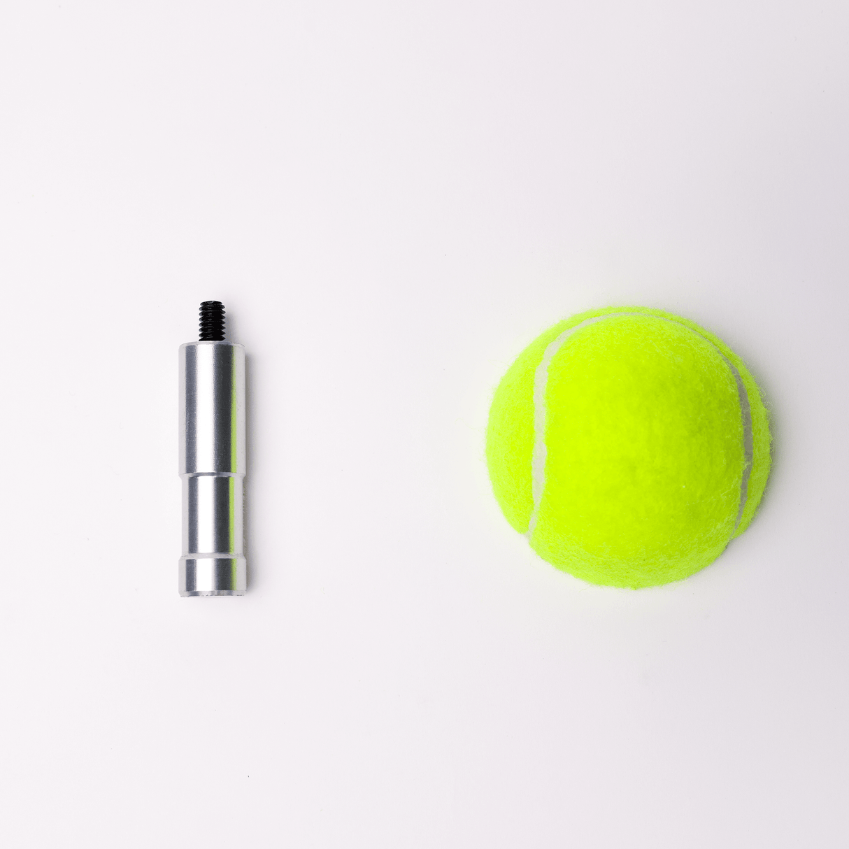 Aluminum connector next to a bright green tennis ball on a white background.