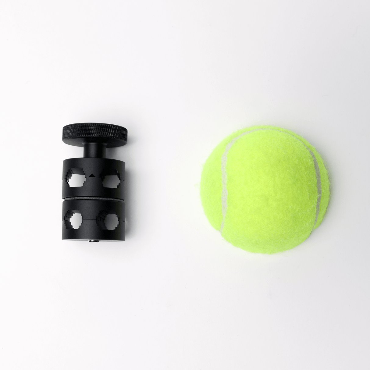MicroGrip accessory next to a tennis ball, showcasing compact rigging solutions for mounting equipment.