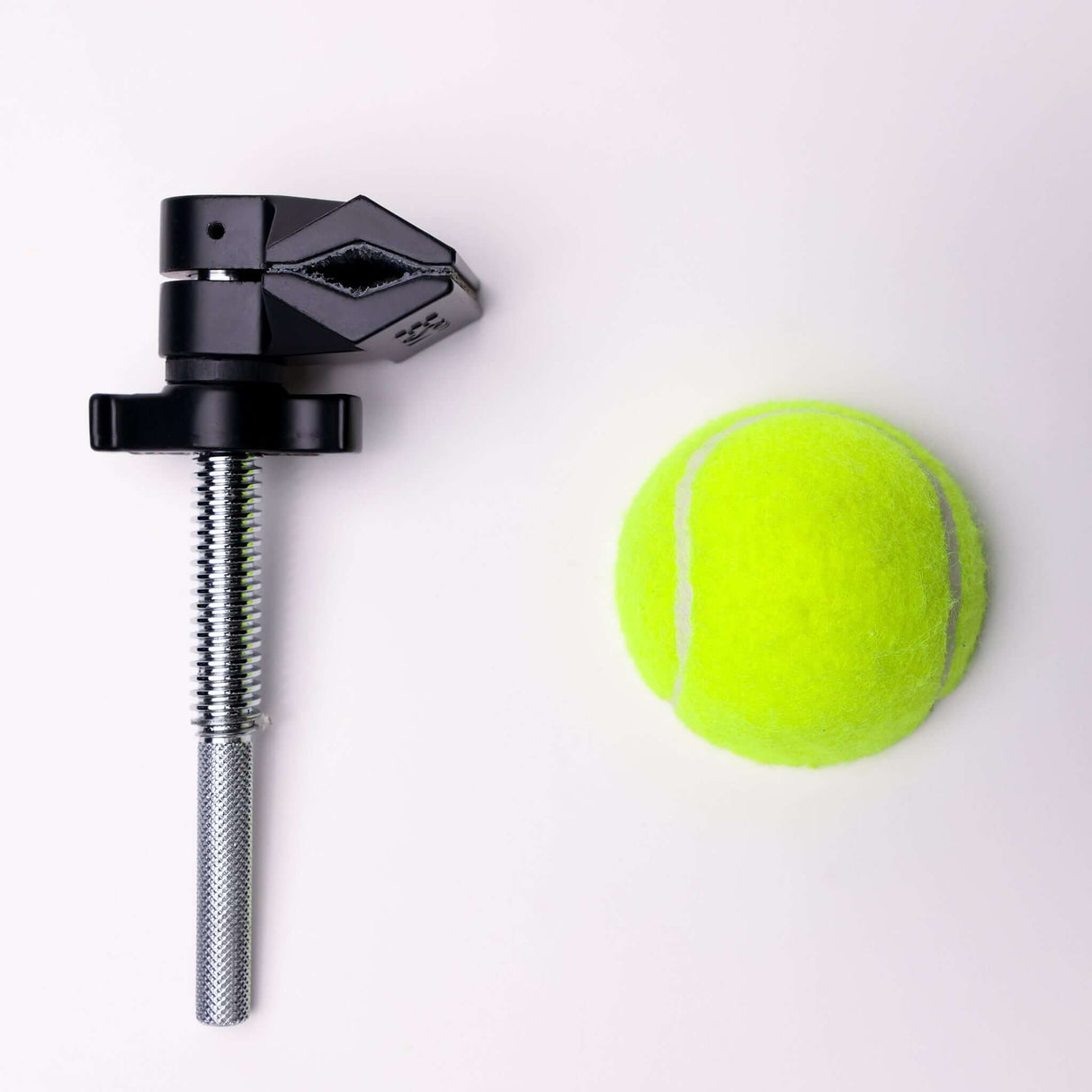 MicroGrip rigging clamp next to a bright yellow tennis ball on a light background.