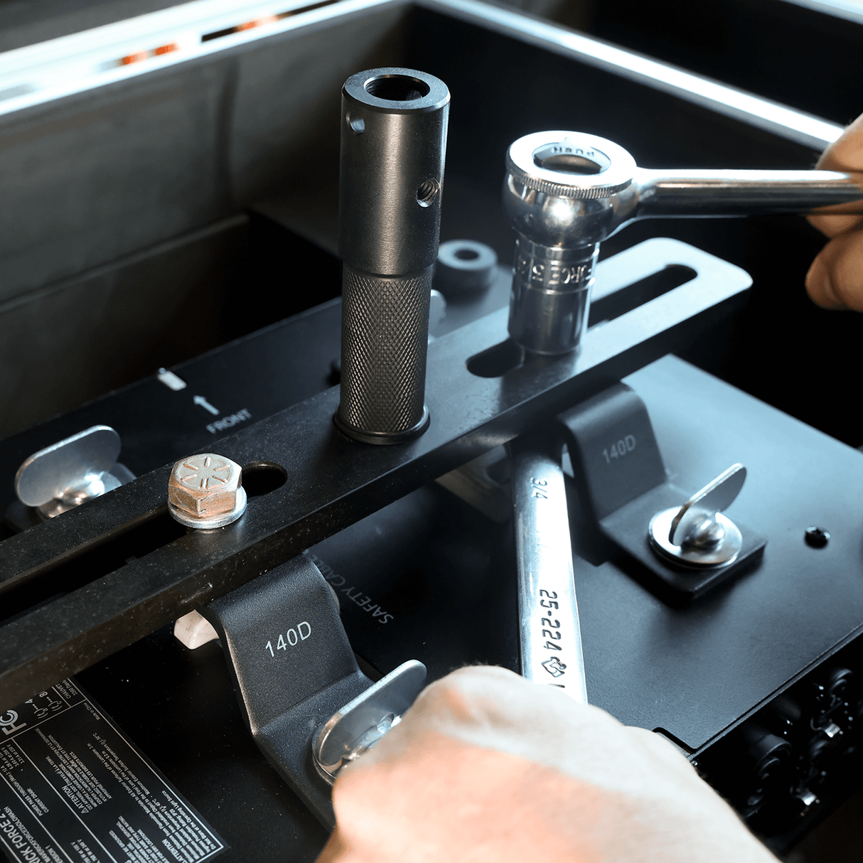 technician adjusting a moving light stand adapter with a wrench in a production setup