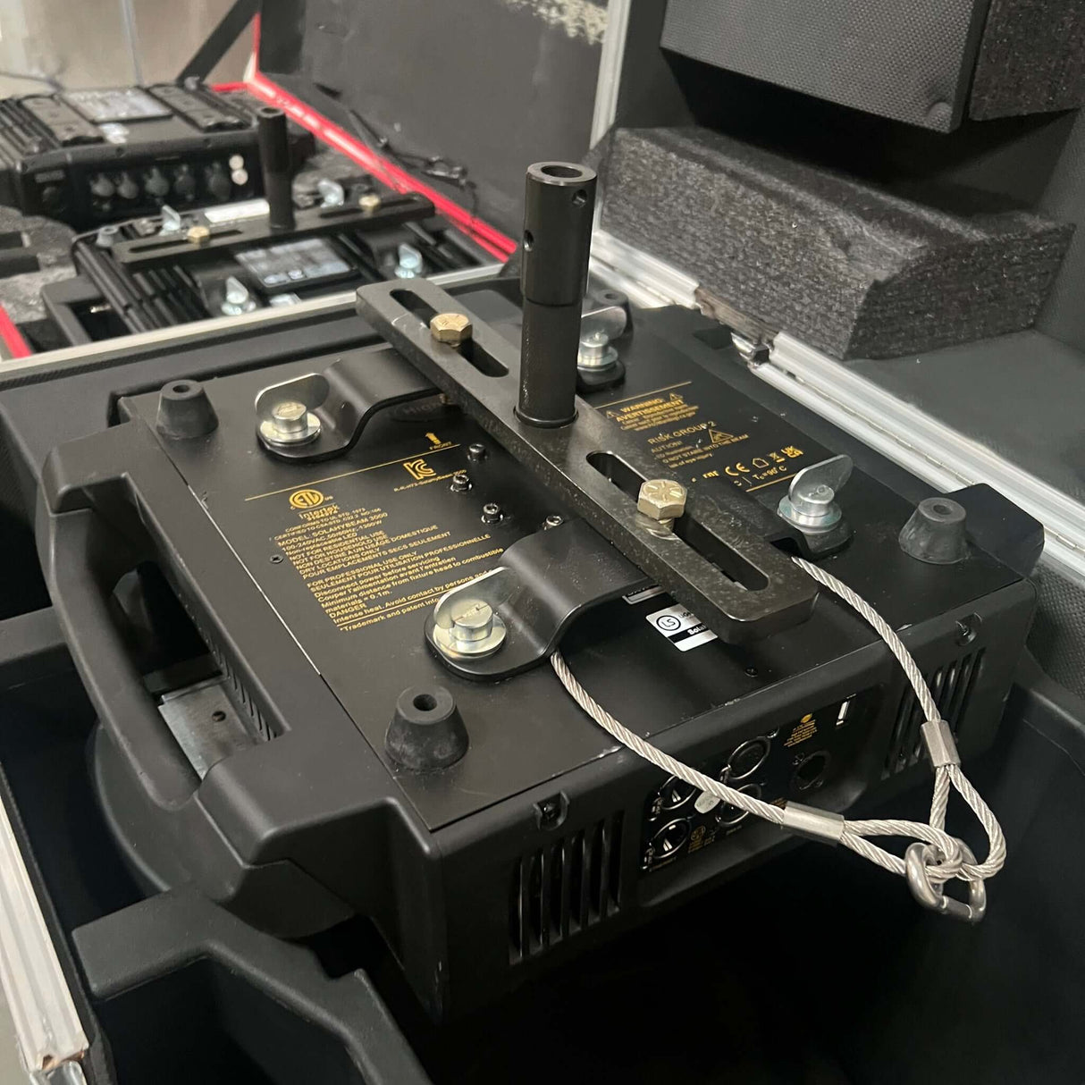 Moving Light Stand Adapter "Cotone Mount" securely attached to a professional lighting fixture in a travel case.