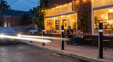 Black Bollards by Matthews with reflective bands protecting a storefront cafe from street traffic