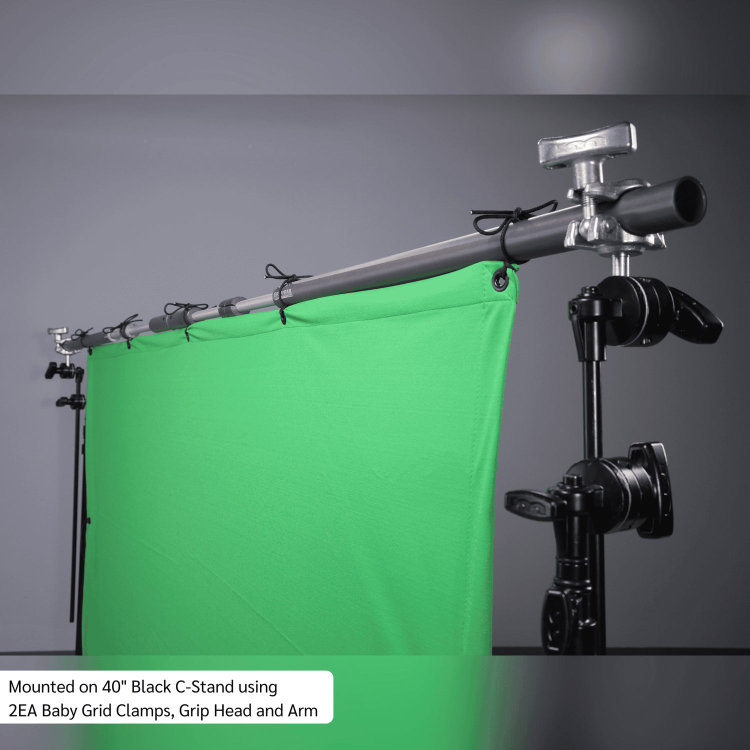 Grip Rail mounted on a black C-Stand with green backdrop, featuring Baby Grid Clamps and Grip Head for versatile setups.