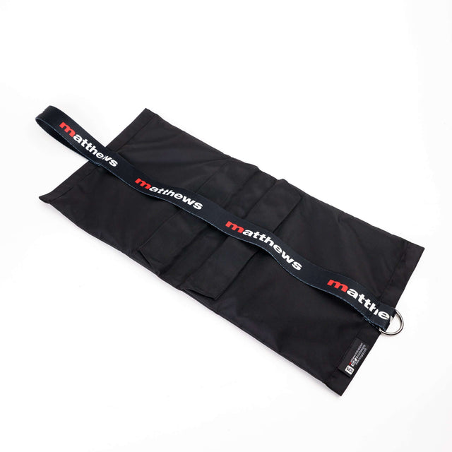 Matthews black sandbag with adjustable strap, designed for secure equipment stabilization on set.
