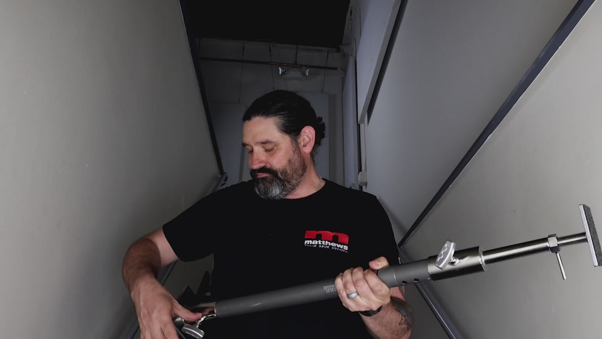 Grip Rail with wall spreader ends tensioned between two walls in a hallway, showing the pressure pads and adjustment