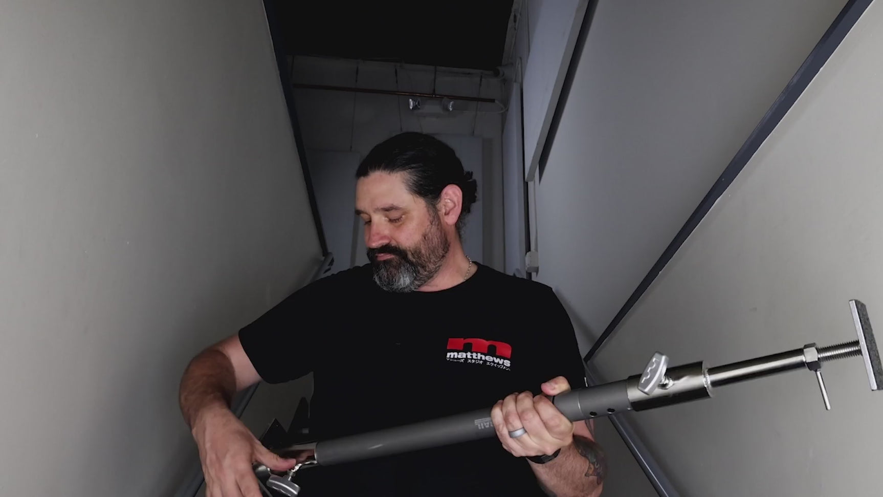 Grip Rail with wall spreader ends tensioned between two walls in a hallway, showing the pressure pads and adjustment