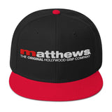 Matthews Snapback Hat featuring a sleek black design with a red bill and logo, ideal for stylish functionality.